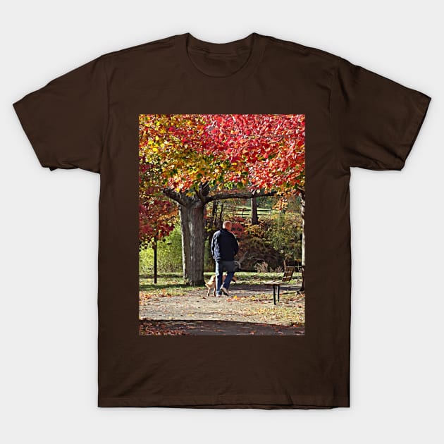 Man Walking Dog in Autumn Park T-Shirt by SusanSavad